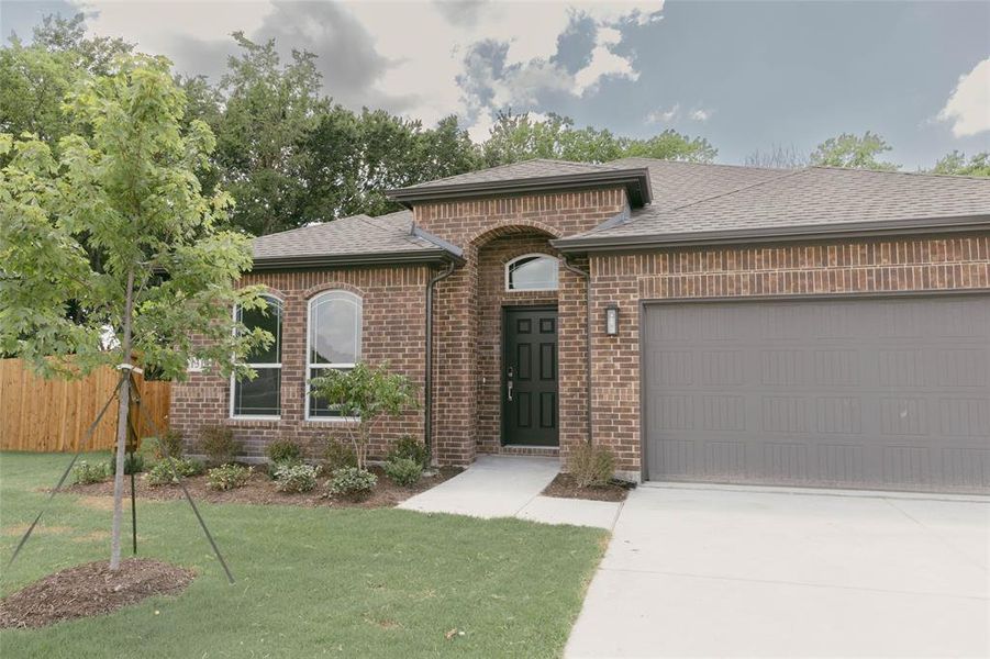 View of front of home with a garage and a front lawn