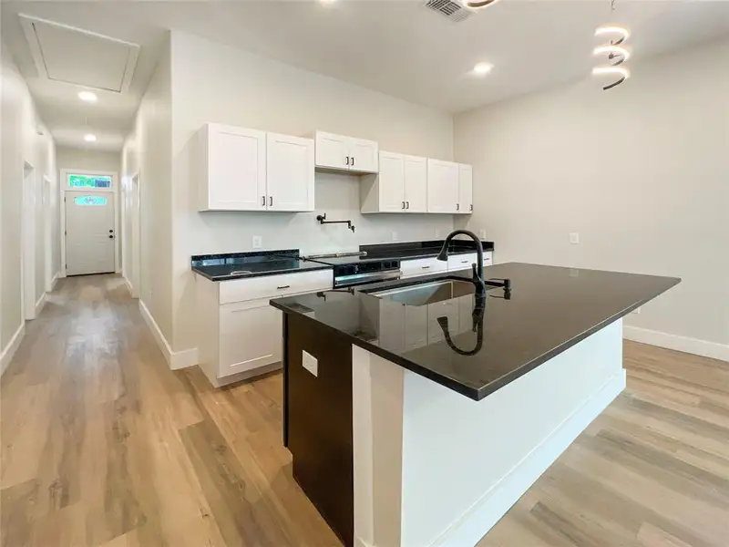 Kitchen with a sink, baseboards, light wood-style floors, white cabinetry, and range Kitchen with a sink, baseboards, light wood-style floors, white cabinetry, and range