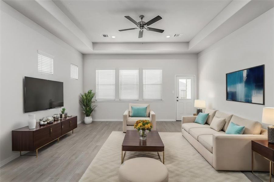 Relax and unwind in the expansive living room, featuring large windows that let in plenty of natural light. The ceiling fan adds comfort, while the neutral color palette provides a serene backdrop for your decor. This versatile space is perfect for family gatherings and casual lounging. Photos are from another Rylan floor plan.