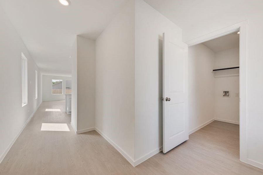 Hall with light wood-style floors and recessed lighting