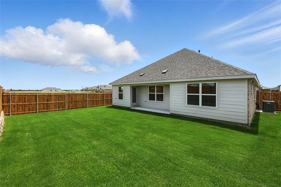 Rear view of house featuring a shingled roof and a fenced backyard Rear view of house featuring a shingled roof and a fenced backyard