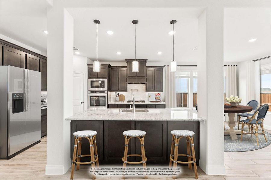 Kitchen with dark cabinets, granite island with three bar stools, pendant lights, and stainless steel appliances Kitchen with dark cabinets, granite island with three bar stools, pendant lights, and stainless steel appliances