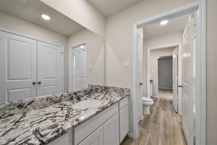 Sleek, elegant bathroom featuring a striking marble-patterned vanity, modern lighting, and ample storage.