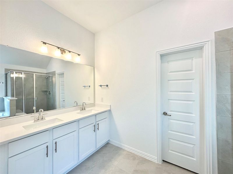 Full bath featuring a stall shower and double vanity Full bath featuring a stall shower and double vanity