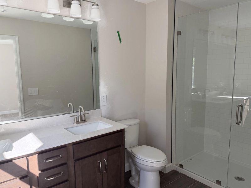 Primary bathroom featuring aspects of AW Collection® Roosevelt, double sinks and a frameless walk-in shower - under construction