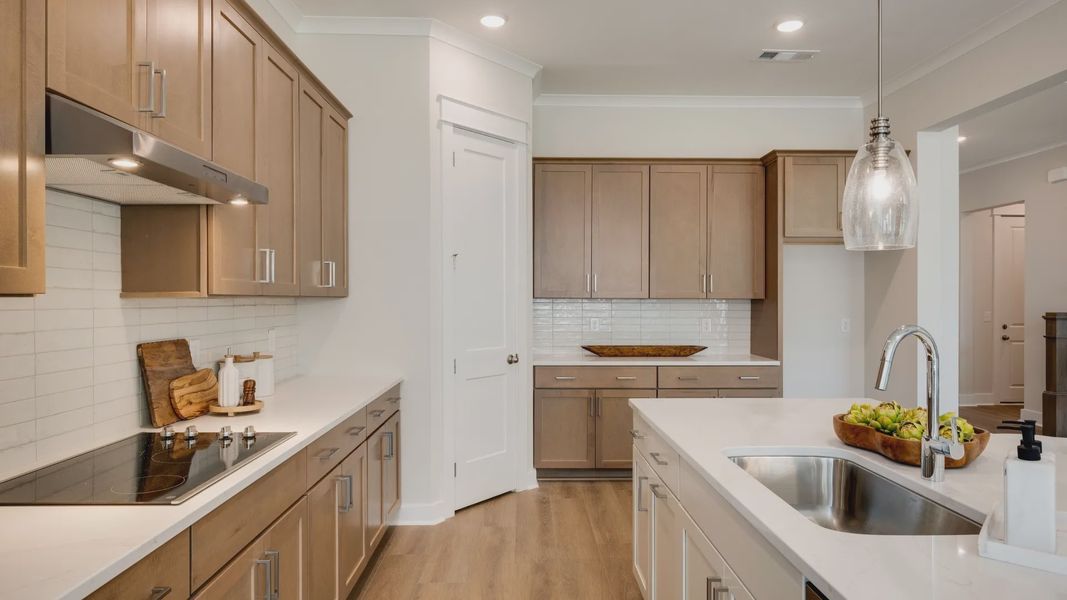 Sink and dishwasher paired with kitchen island next to staircase