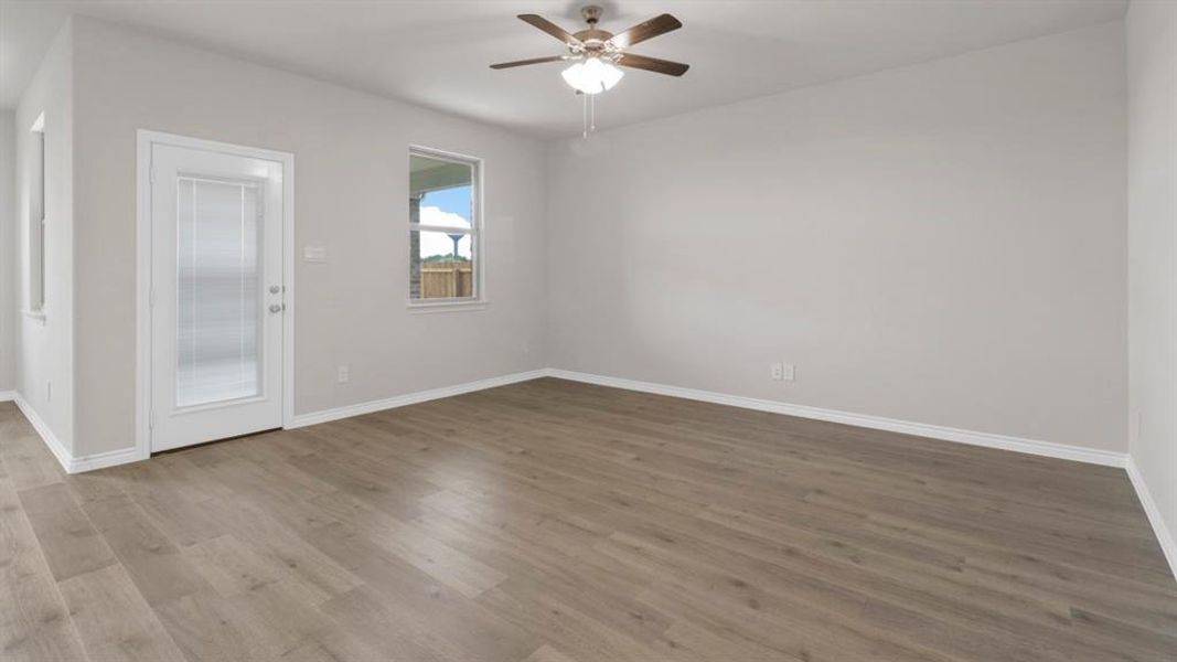 Empty room with a ceiling fan and dark wood finished floors
