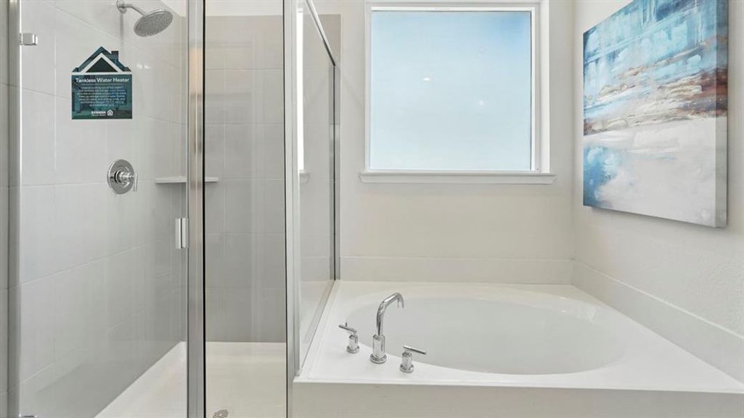 Bathroom featuring a built-in soaking tub with chrome fixtures, a clear glass shower enclosure, and white tile surrounds