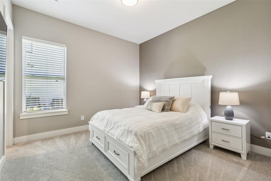 Bedroom featuring light carpet