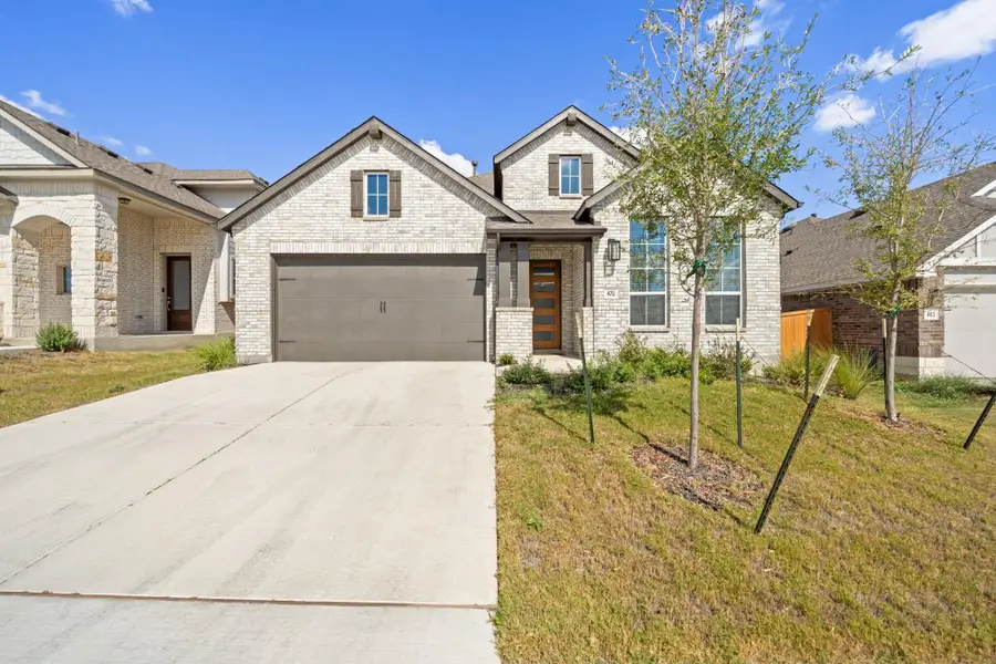 View of front of home featuring brick siding, concrete driveway, a front yard, and an attached garage