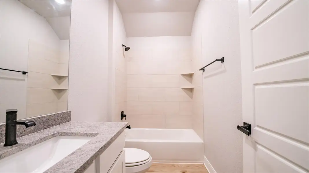 Bathroom with vanity, shower / tub combination, and light wood finished floors Bathroom with vanity, shower / tub combination, and light wood finished floors