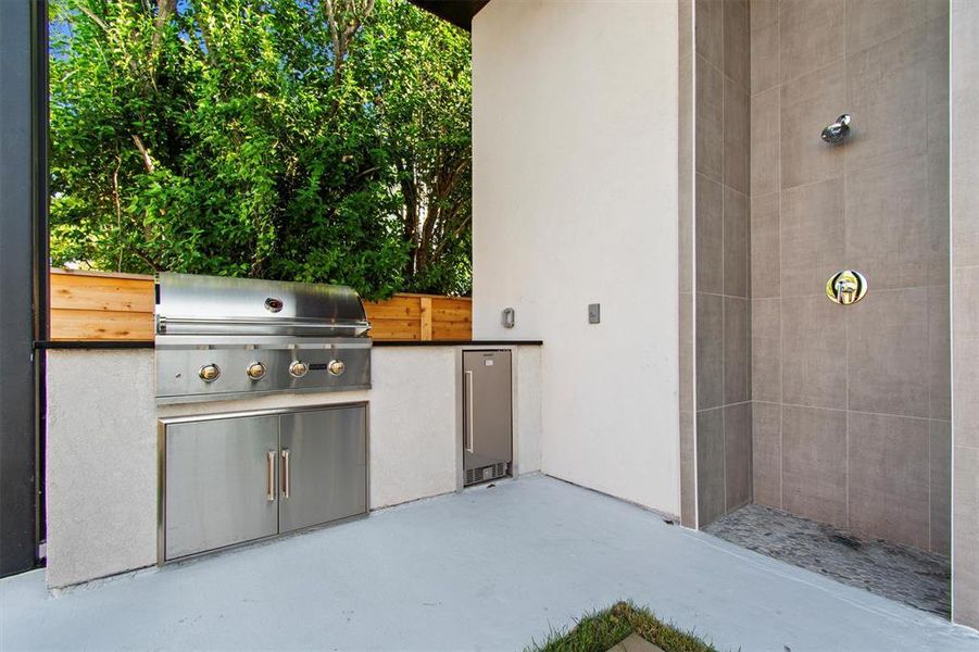 The outdoor kitchen and shower area elevate your outdoor living experience. Equipped with a high-end grill and a sleek shower, it's the ideal setup for rinsing off after a swim or hosting an al fresco dinner party. This space seamlessly combines luxury with practicality, making every day feel like a vacation.