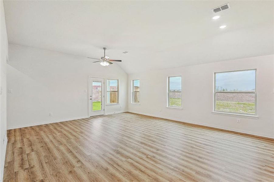 Unfurnished room with ceiling fan, light hardwood / wood-style floors, and lofted ceiling