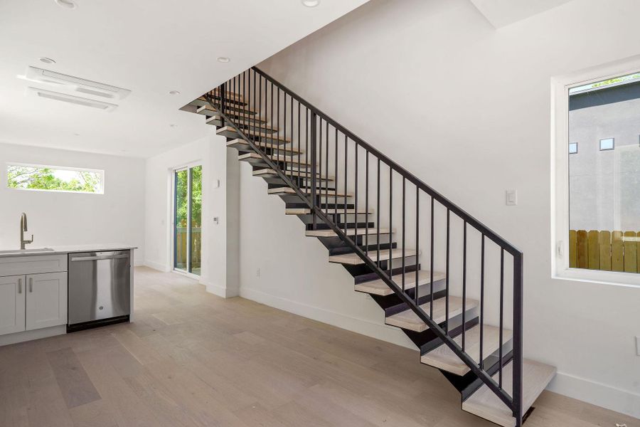 Stairs with wood finished floors and baseboards
