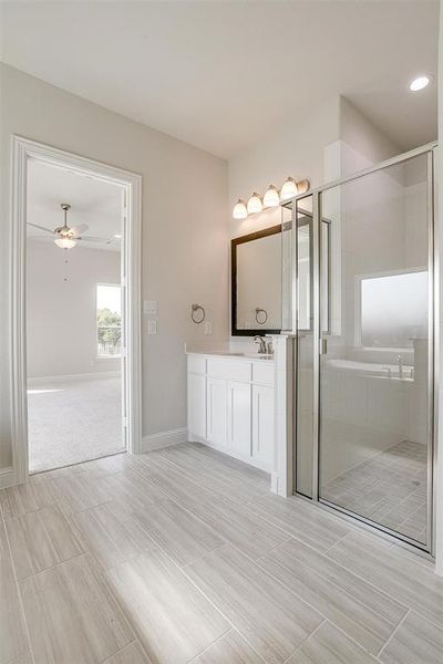 Bathroom with vanity, plus walk in shower, and ceiling fan