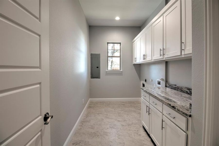 Clothes washing area with cabinets, hookup for a washing machine, electric panel, and electric dryer hookup