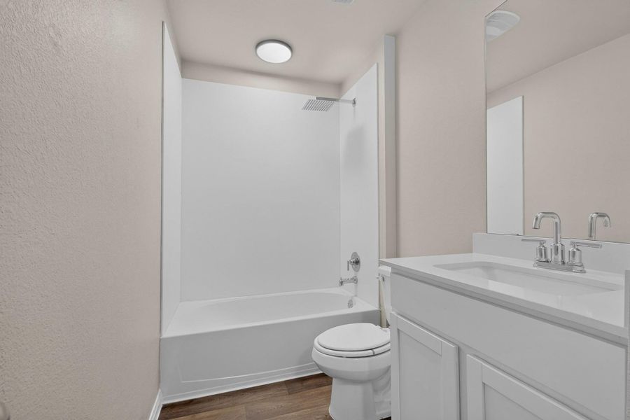 Clean lines and durable vinyl flooring define this modern secondary bathroom.