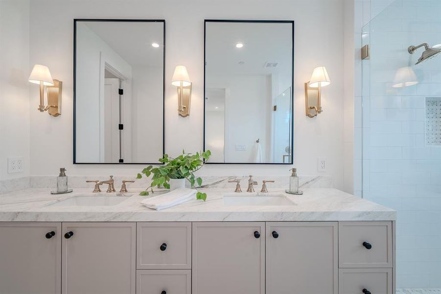 Full bath with double vanity, tiled shower, and recessed lighting