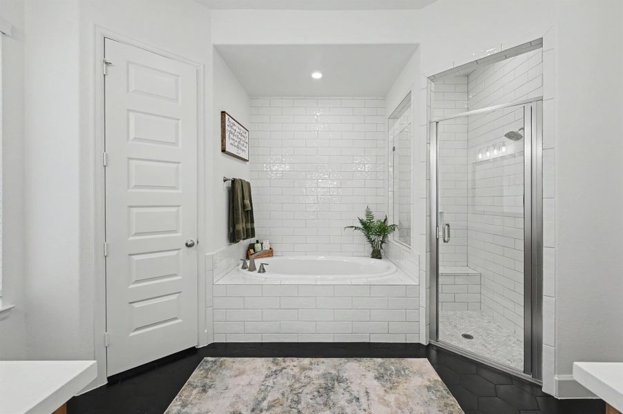 This bathroom is stunning! The black octagonal tile flooring was upgraded in this bathroom, as well. The large garden tub is accented by subway tile to the ceiling on the back wall. The walk-in shower has bench seating and subway tile to the ceiling. The door on the left has a toilet and a 42" maple stained cabinet was added. This bathroom is stunning! The black octagonal tile flooring was upgraded in this bathroom, as well. The large garden tub is accented by subway tile to the ceiling on the back wall. The walk-in shower has bench seating and subway tile to the ceiling. The door on the left has a toilet and a 42" maple stained cabinet was added.