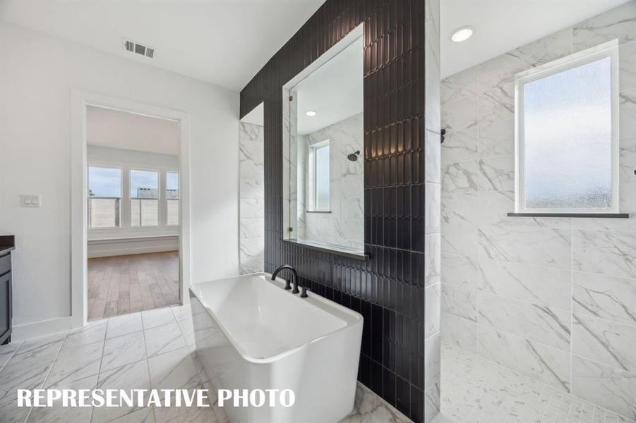 Featuring our signature walk through shower with dual shower heads and free standing tub, you'll enjoy a spa like experience every day in this over the top owner's bath!  REPRESENTATIVE PHOTO