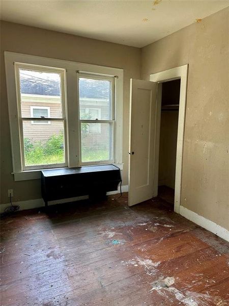 Bedroom featuring hardwood / wood-style floors and a closet Bedroom featuring hardwood / wood-style floors and a closet