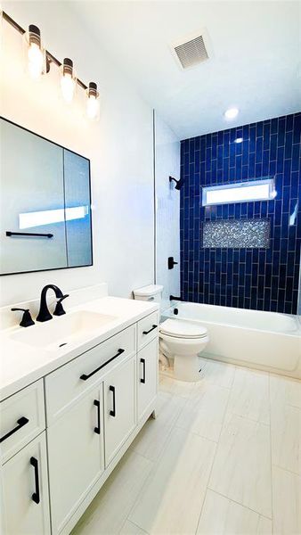 Full bathroom featuring vanity, toilet, and tiled shower / bath