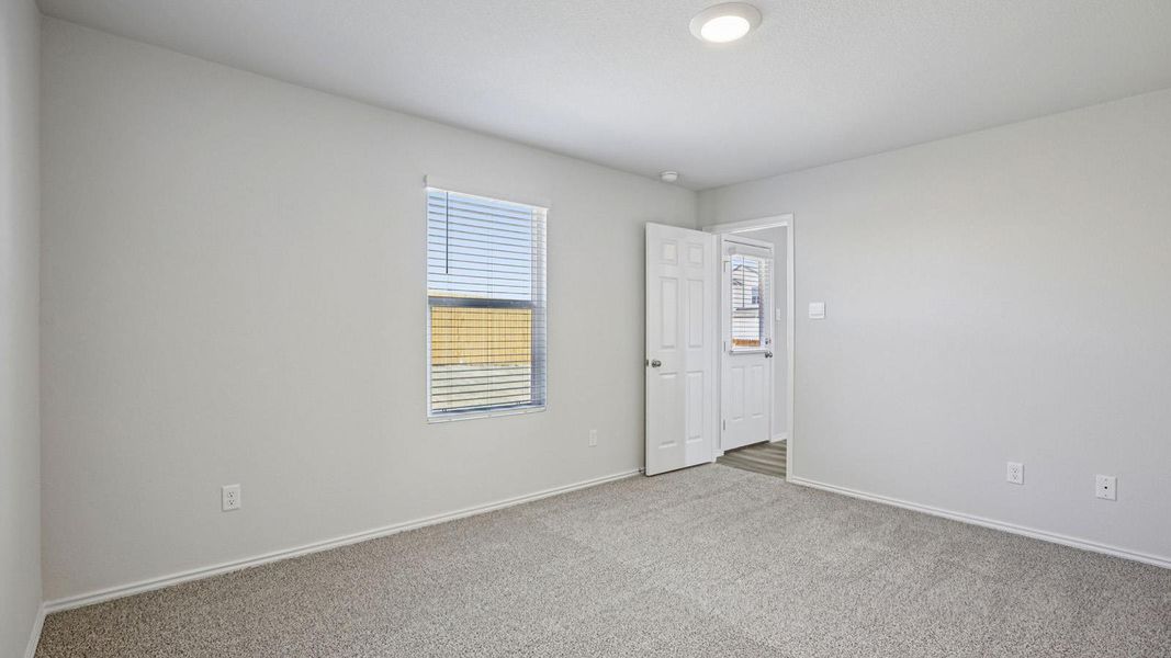 Carpeted spare room featuring baseboards