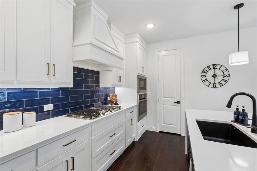 Kitchen
A bold blue tile backsplash creates a memorable focal point, complemented by a gas cooktop, double ovens, and abundant preparation space.