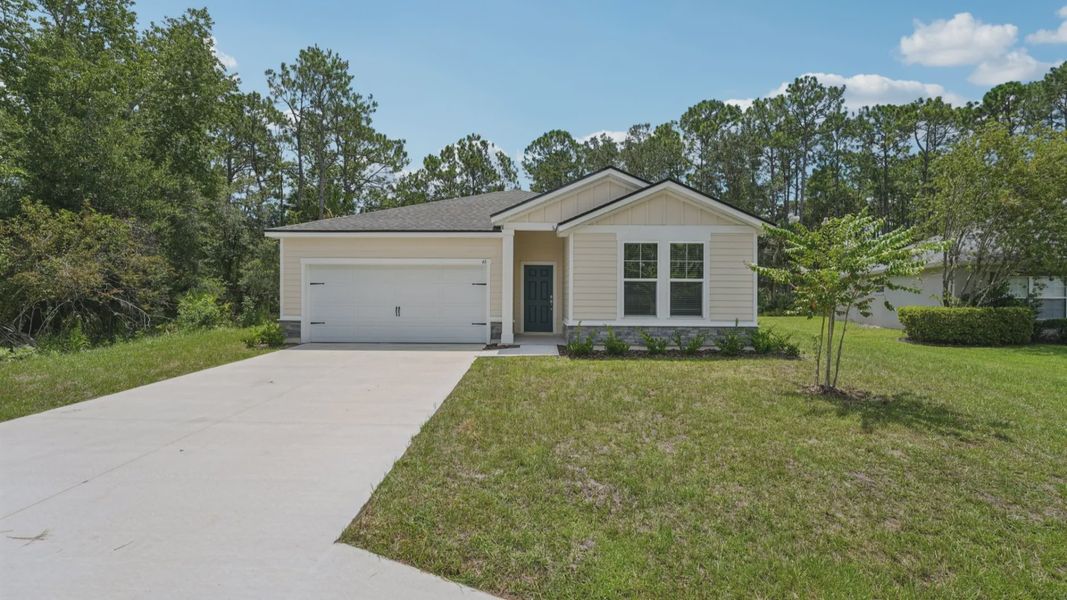 Elegant stone accents and expansive driveway elevate this Palm Coast residence's sophisticated facade.