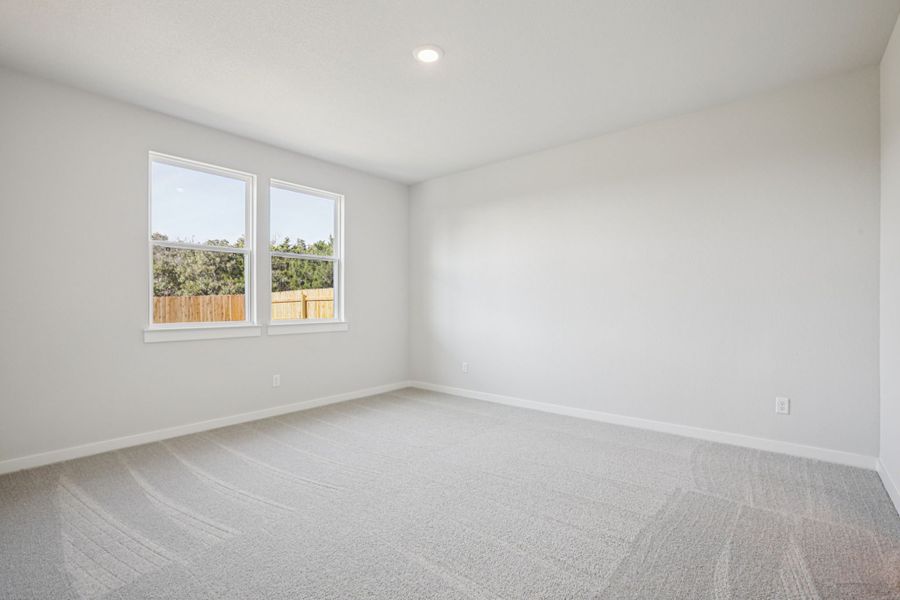 A room with a window and a white wall.