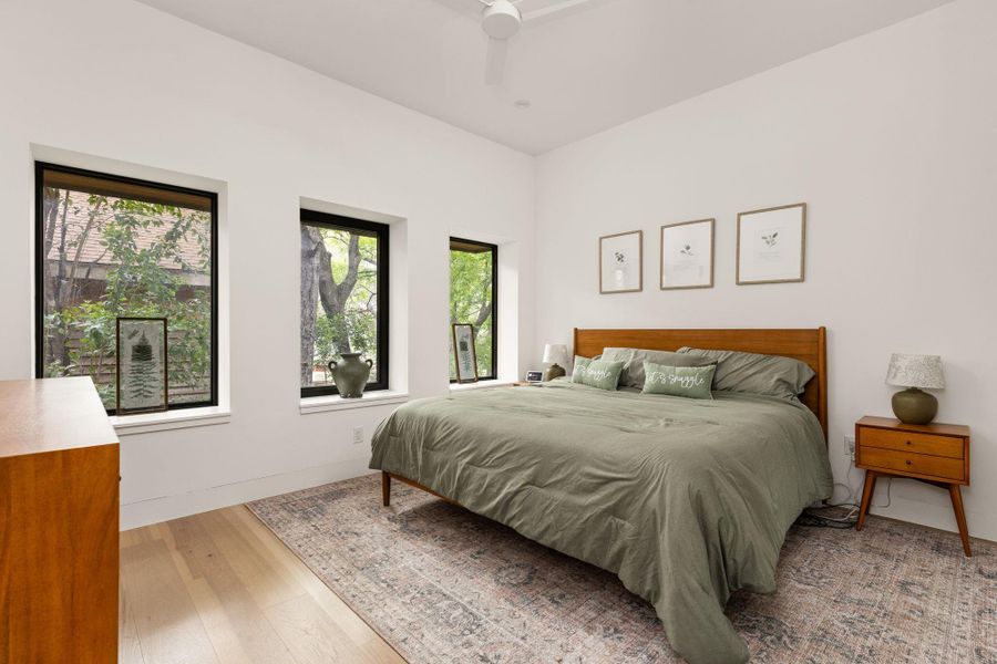 Hardwood floors and generous windows elevate this serene bedroom space. Hardwood floors and generous windows elevate this serene bedroom space.