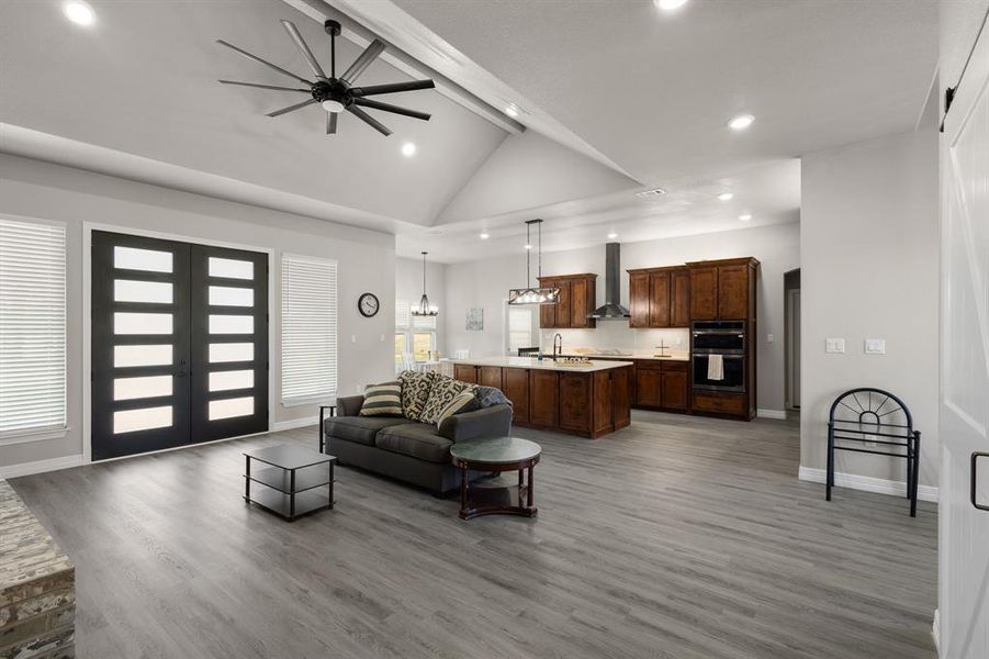 Living area featuring recessed lighting, light wood-style floors, ceiling fan, french doors, and high vaulted ceiling