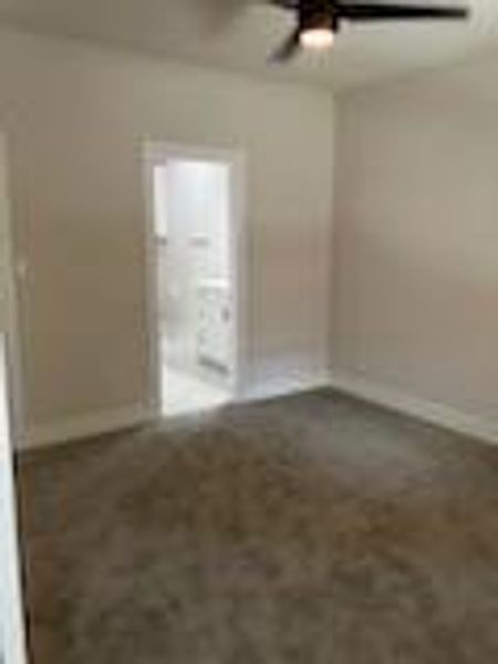 Primary bedroom with carpet and ceiling fan