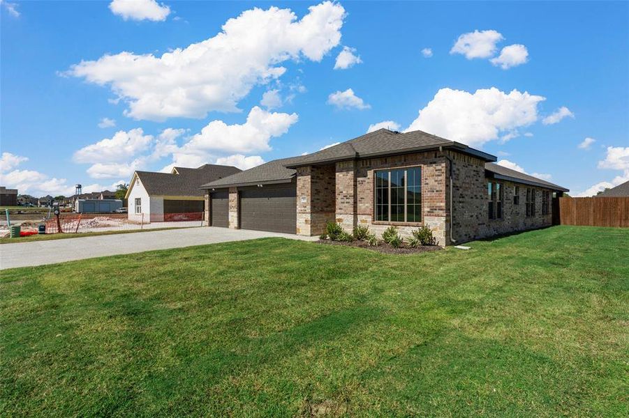 View of front facade featuring a front lawn and a garage