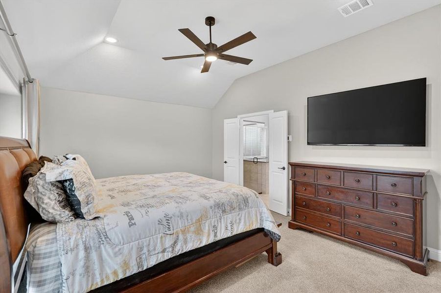 Carpeted room featuring a vaulted ceiling with a ceiling fan Carpeted room featuring a vaulted ceiling with a ceiling fan