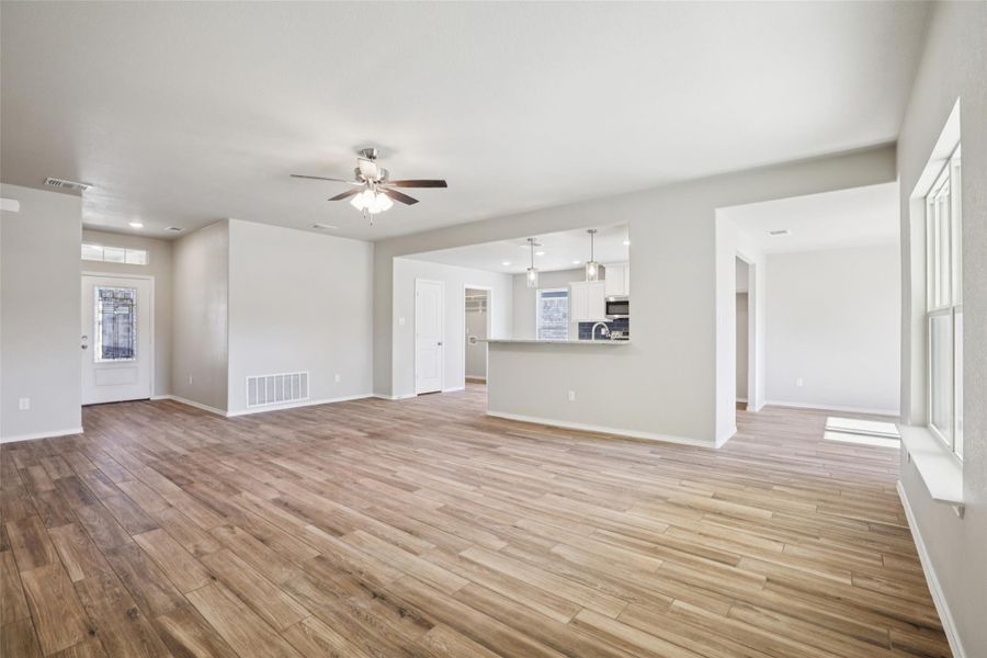 Unfurnished living room with a ceiling fan, light wood finished floors, and recessed lighting