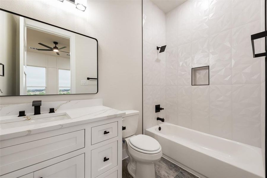 Full bathroom featuring vanity, toilet, bathtub / shower combination, and a ceiling fan Full bathroom featuring vanity, toilet, bathtub / shower combination, and a ceiling fan