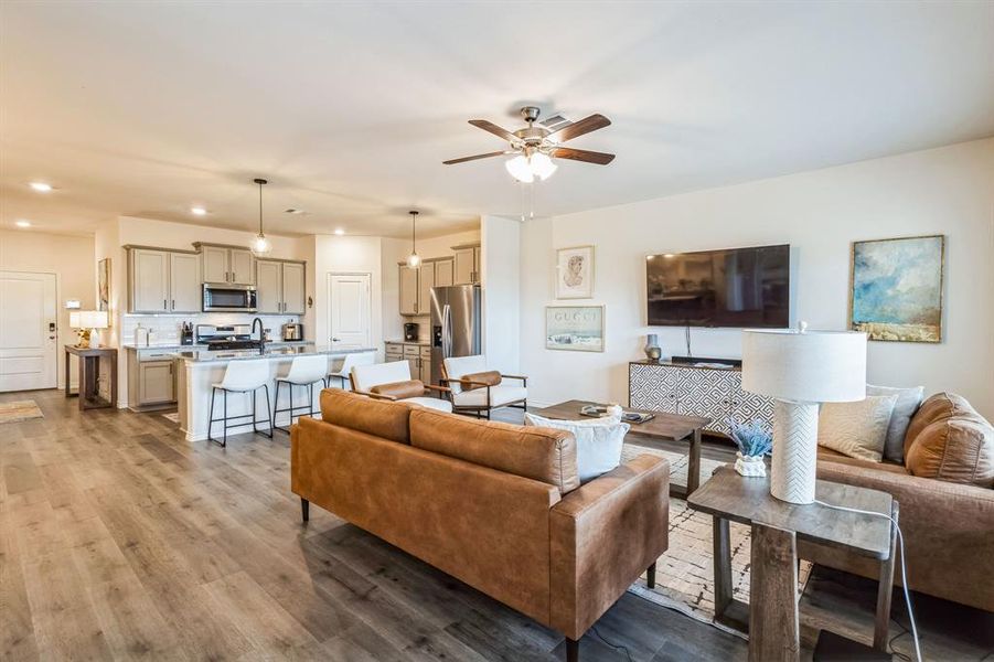 Living room featuring ceiling fan, wood-type flooring, and sink