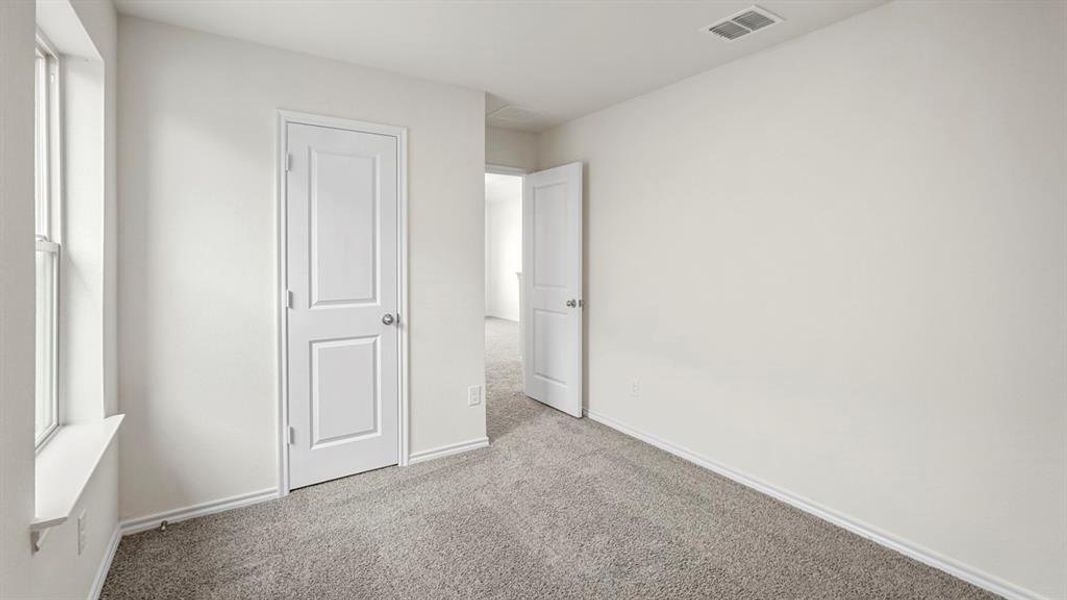Neutral-toned interior room featuring light gray carpet flooring and white painted walls