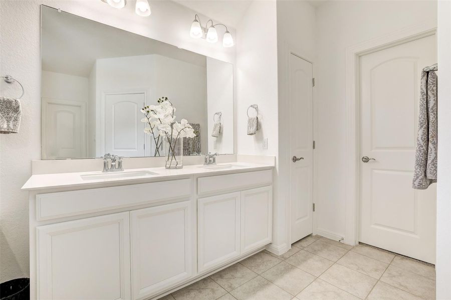 Bathroom with double vanity and tile patterned flooring