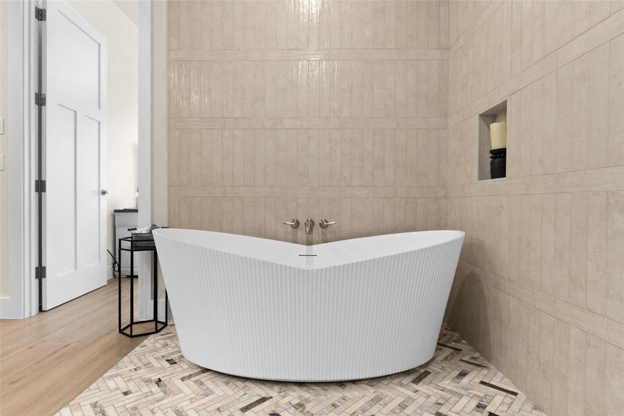 Bathroom featuring a freestanding tub, tile walls, and wood finished floors