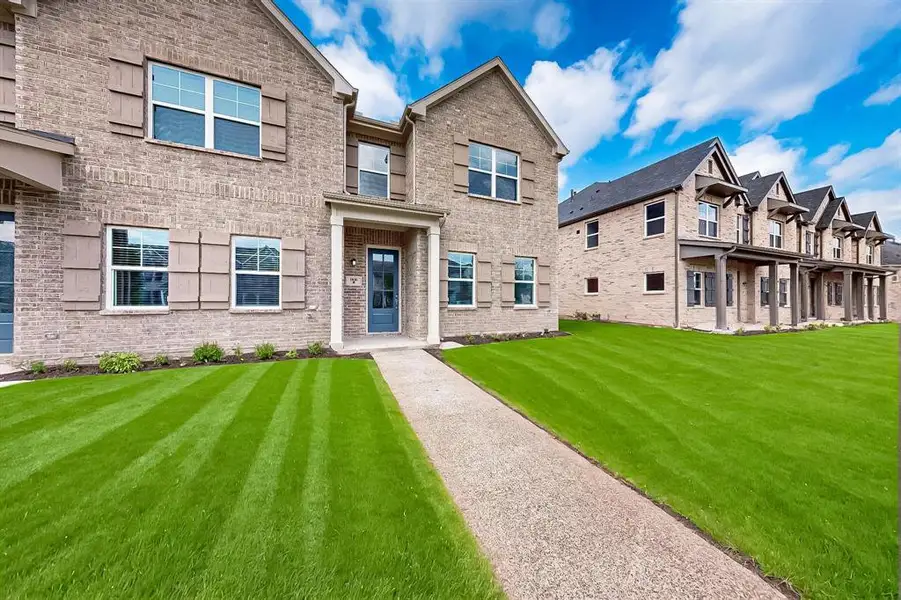 View of front of home featuring brick siding and a front yard
