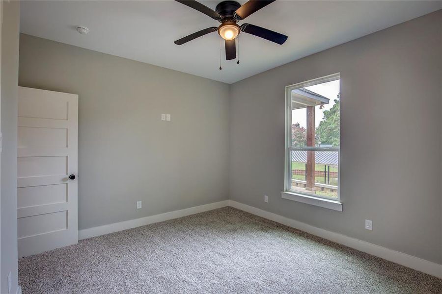 Carpeted empty room featuring ceiling fan