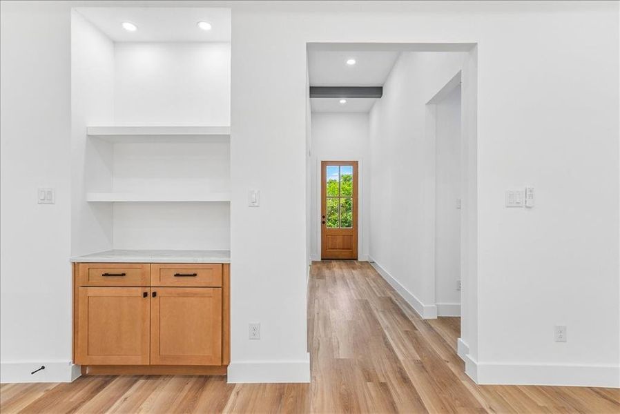 Warm wood-finish flooring complements the built-in cabinetry with natural wood tones and a light-toned countertop Warm wood-finish flooring complements the built-in cabinetry with natural wood tones and a light-toned countertop