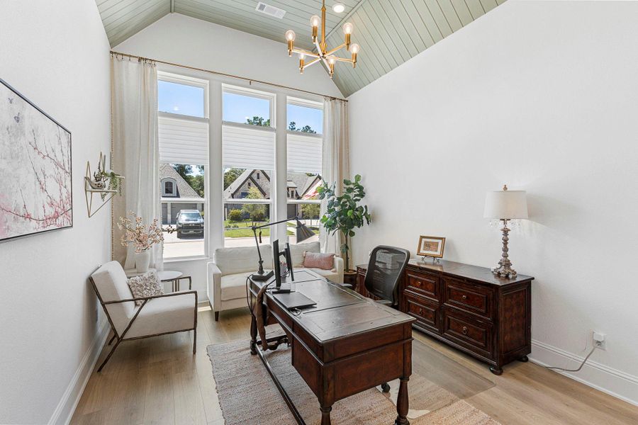 Bright and spacious home office featuring a vaulted ceiling and large windows that fill the room with natural light.
