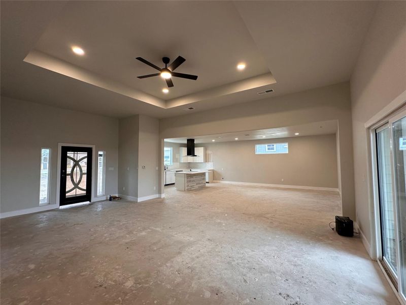 Unfurnished living room featuring ceiling fan, recessed lighting, and unfinished concrete flooring