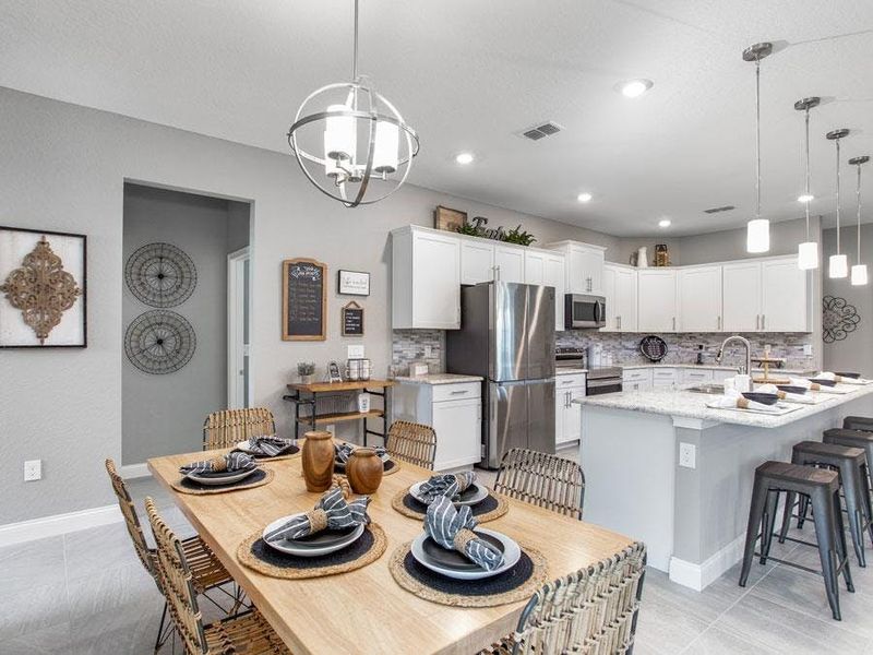 A cafe and counter-height island provide dining space - Waylyn by Highland Homes A cafe and counter-height island provide dining space - Waylyn by Highland Homes