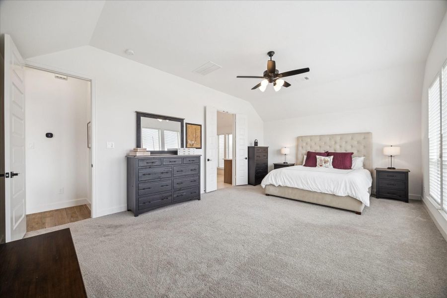 The spacious primary is lined with a wall of windows and plenty of space for a seating area.