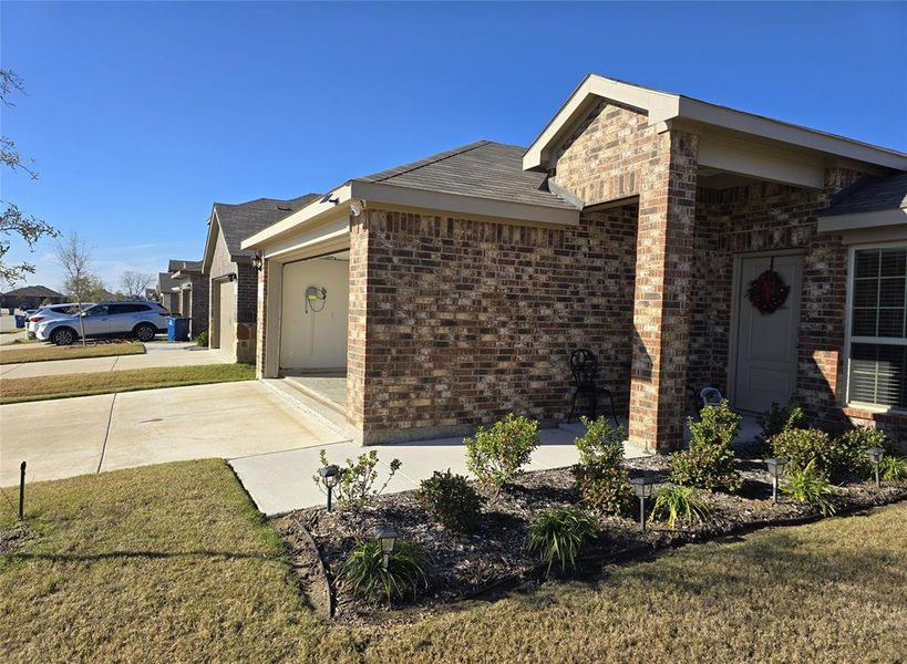 View of property exterior with a lawn and a garage