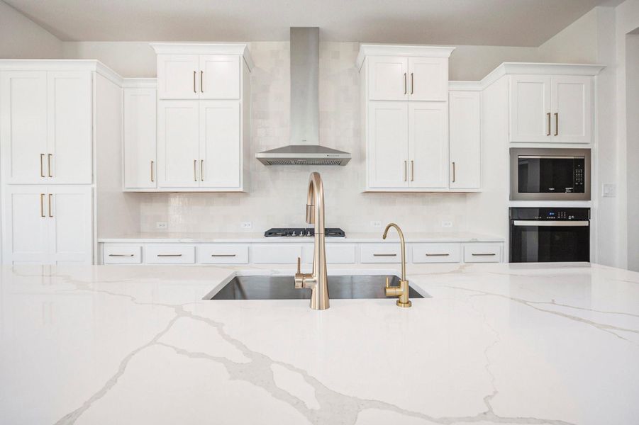 The gourmet kitchen showcases white cabinetry, quartz countertops, and high-end finishes that exude timeless luxury. Designed with both beauty and function in mind, this stunning space offers a clean, modern aesthetic complemented by premium fixtures and thoughtful details—perfect for both everyday living and elegant entertaining.